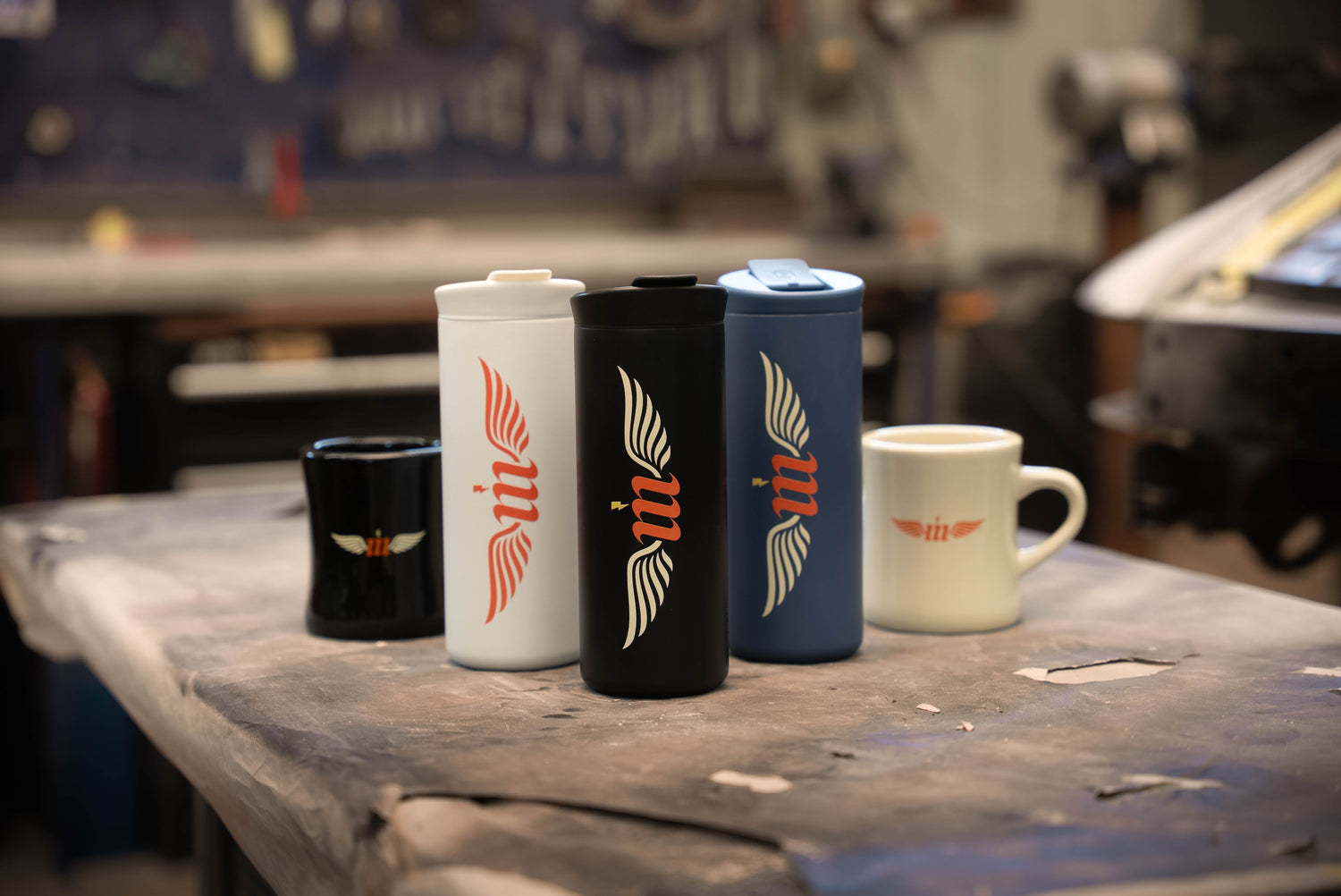 selction of five mugs on a work table in an automotive body shop