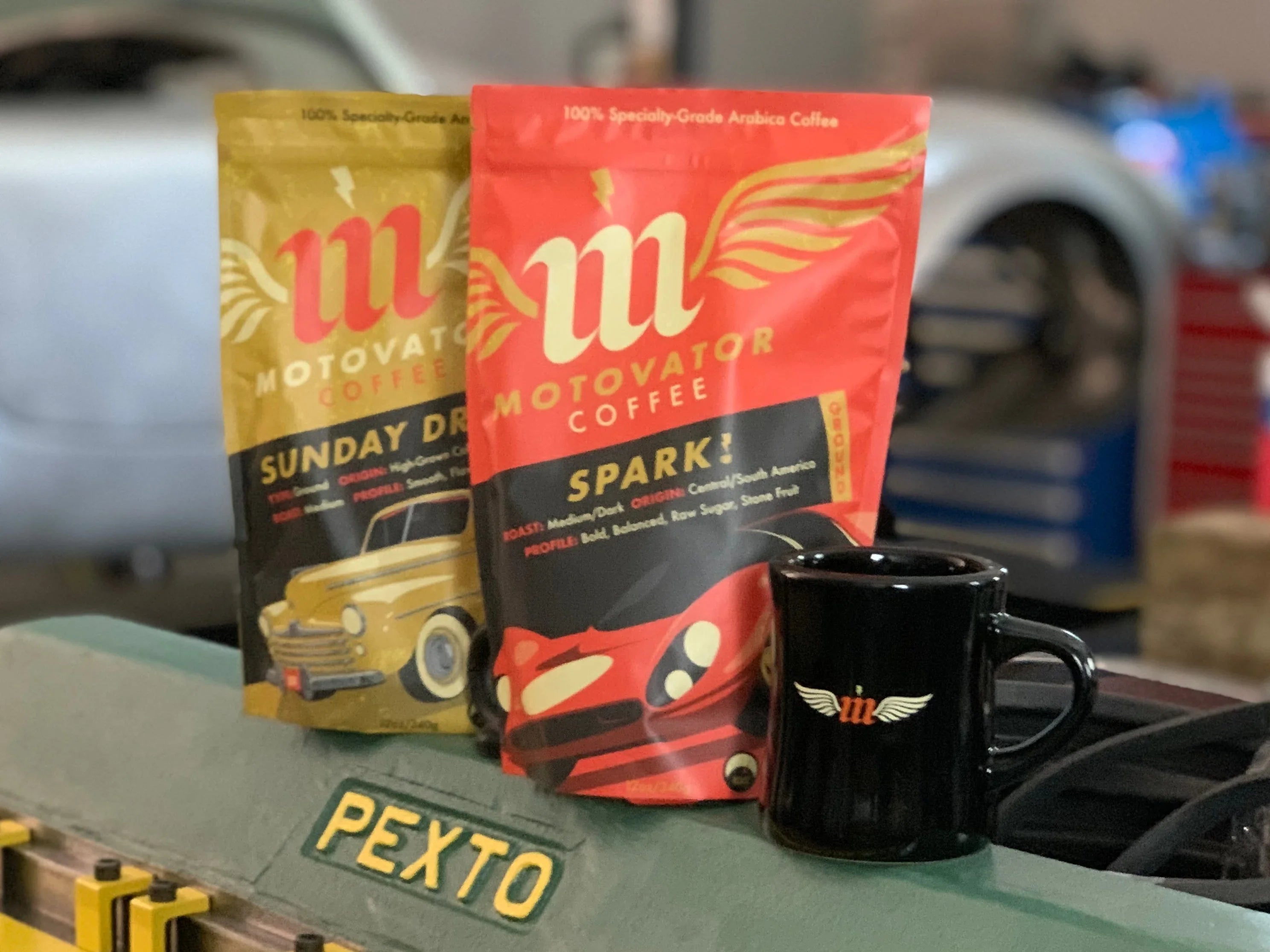 two coffee bags and a mug on a vintqge Pexto tool in an automotive workshop