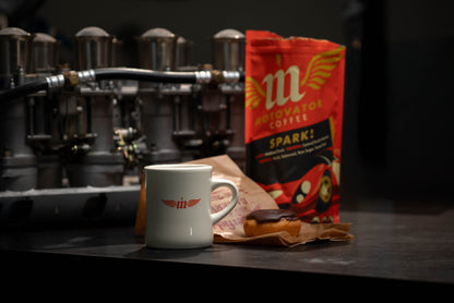 Mug and coffee and donut bag on a counter with weber careurator intake in the background