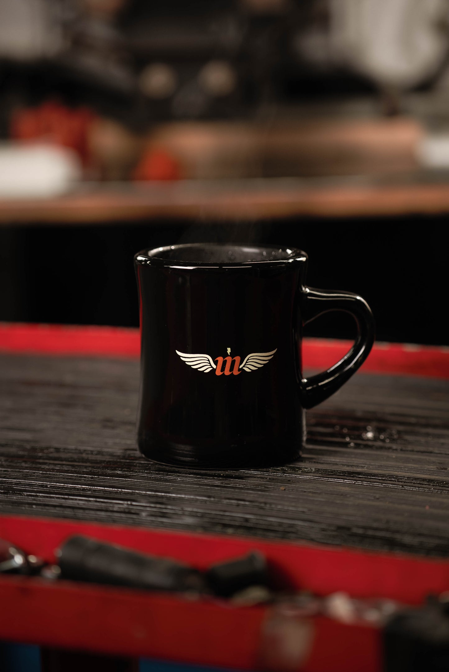 Black Motovator logo Vintage Diner mug on a red tool cart 